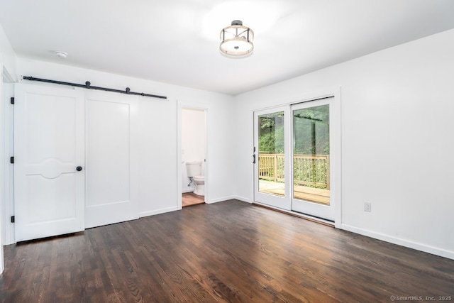 4 Deer Run Trl, Sherman, CT 06784 - unfurnished bedroom with access to exterior, a barn door, dark wood-style floors, and baseboards