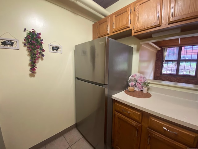 839 Main St Apt 35, Torrington, CT 06790 - kitchen featuring freestanding refrigerator, light tile patterned floors, light countertops, and brown cabinets