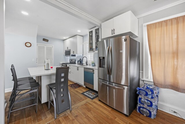 26 Herkimer St, Waterbury, CT 06710 - kitchen with appliances with stainless steel finishes, a sink, hardwood / wood-style flooring, light countertops, and white cabinets