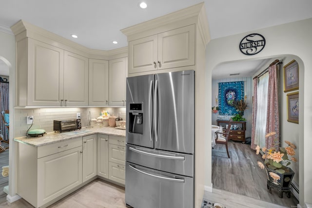 27 N Rd, Waterford, CT 06385 - kitchen featuring stainless steel fridge with ice dispenser, arched walkways, backsplash, light stone countertops, and recessed lighting