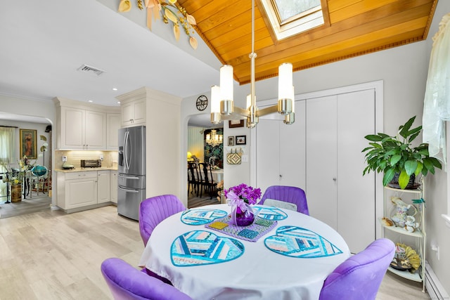 27 N Rd, Waterford, CT 06385 - dining space featuring baseboard heating, lofted ceiling, light wood-style floors, a chandelier, and a skylight