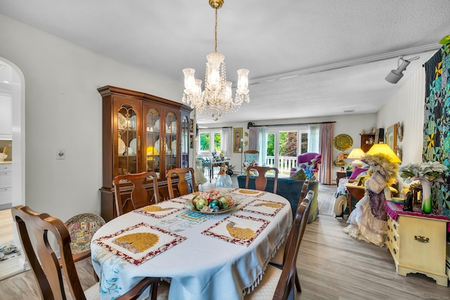 27 N Rd, Waterford, CT 06385 - dining space featuring wood finished floors, arched walkways, a chandelier, and a textured ceiling