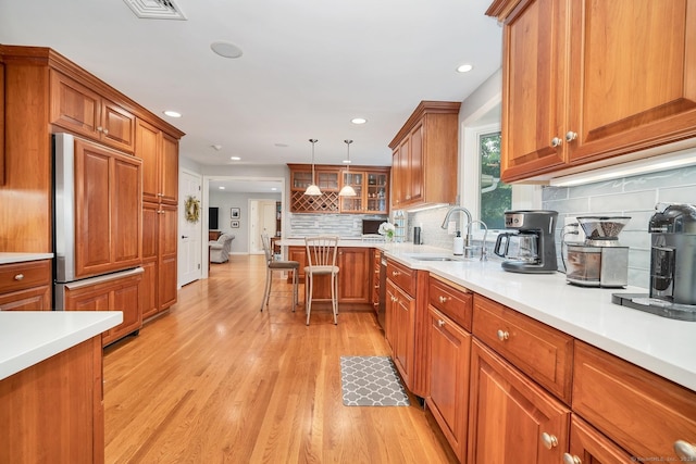 67 Great Hill Rd, Ridgefield, CT 06877 - kitchen with paneled built in refrigerator, a sink, brown cabinetry, light wood-style floors, and decorative backsplash