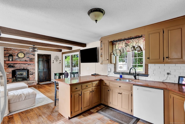 47 Edrow Rd, Bristol, CT 06010 - kitchen featuring white dishwasher, a wood stove, open floor plan, a peninsula, and a textured ceiling