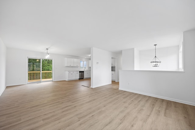 23 Shadybrook Ln, Waterbury, CT 06706 - unfurnished living room with a chandelier and light wood-style floors