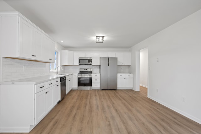 23 Shadybrook Ln, Waterbury, CT 06706 - kitchen featuring appliances with stainless steel finishes, light wood-style flooring, decorative backsplash, light countertops, and white cabinets