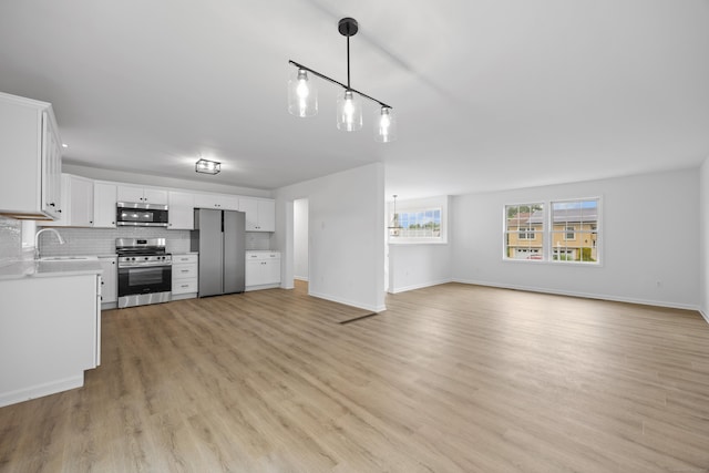 23 Shadybrook Ln, Waterbury, CT 06706 - kitchen featuring stainless steel appliances, light countertops, open floor plan, light wood-style floors, and white cabinetry