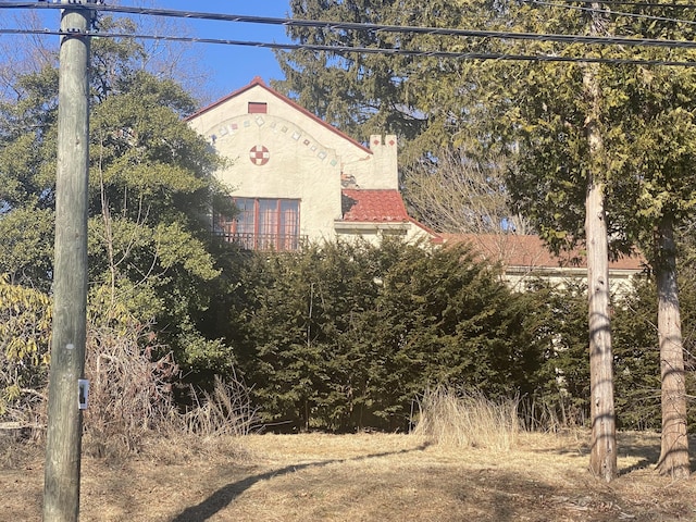 view of side of property with stucco siding and a chimney
