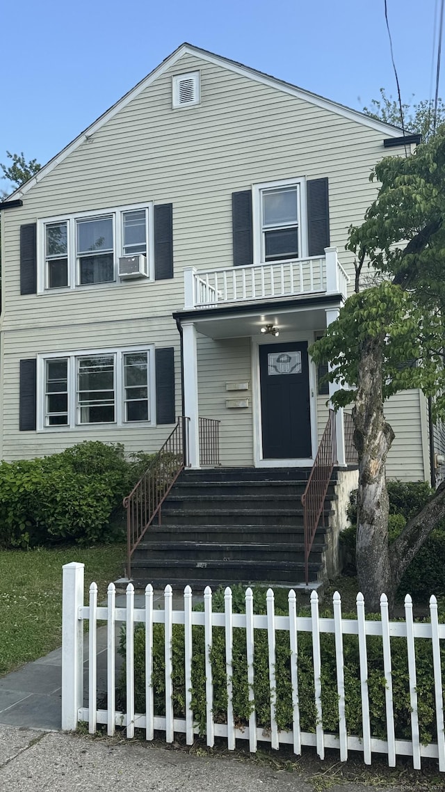 64 Locust St, Bridgeport, CT 06610 - view of front of house featuring covered porch, a fenced front yard, cooling unit, stairway, and a balcony