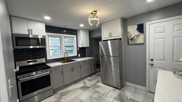 64 Locust St, Bridgeport, CT 06610 - kitchen featuring stainless steel appliances, a sink, tasteful backsplash, baseboards, and white cabinetry