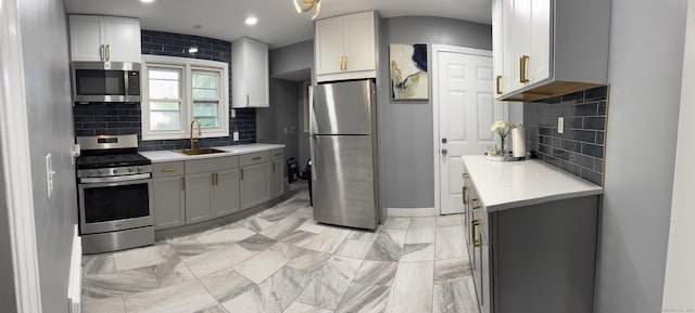 64 Locust St, Bridgeport, CT 06610 - kitchen featuring stainless steel appliances, a sink, light countertops, backsplash, and gray cabinets