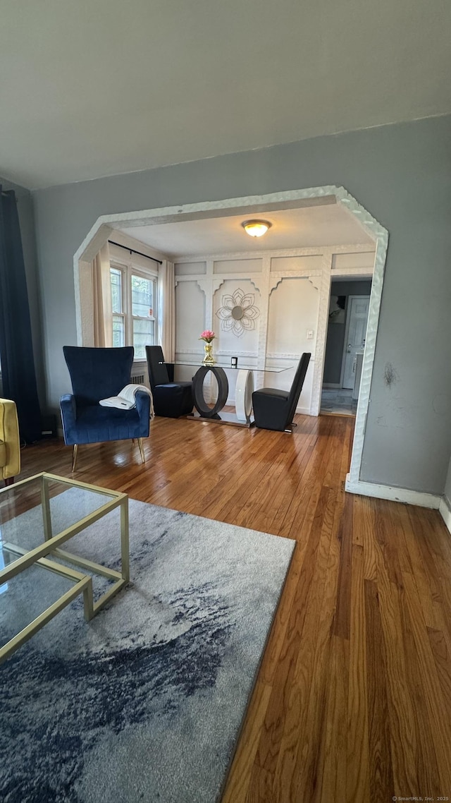 64 Locust St, Bridgeport, CT 06610 - living area featuring wood finished floors, arched walkways, and baseboards