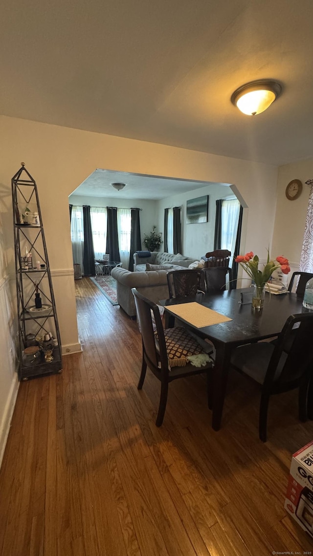 64 Locust St, Bridgeport, CT 06610 - dining room featuring arched walkways, dark wood-style flooring, and baseboards