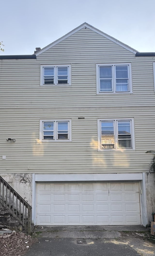 64 Locust St, Bridgeport, CT 06610 - view of side of property featuring an attached garage and stairs