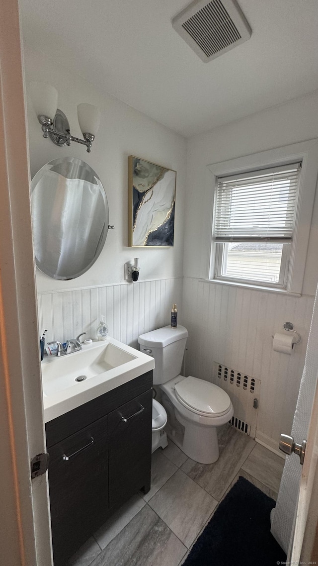 64 Locust St, Bridgeport, CT 06610 - half bathroom featuring radiator, toilet, a wainscoted wall, and vanity