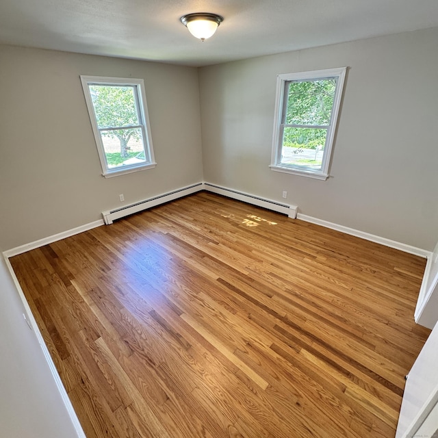 98 N Atwater St, East Haven, CT 06512 - empty room with baseboard heating, healthy amount of natural light, and wood finished floors