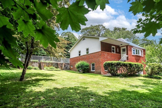 8 Fulton Dr, New Fairfield, CT 06812 - view of side of home featuring brick siding, a yard, and stucco siding