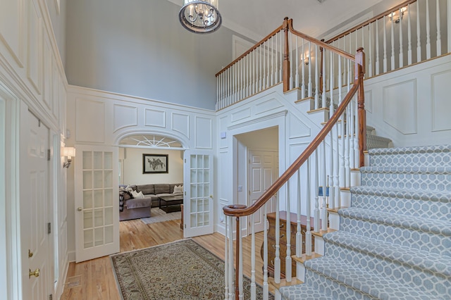 38 Old Trolley Rd, Ridgefield, CT 06877 - foyer featuring french doors, stairway, a decorative wall, a high ceiling, and light wood finished floors