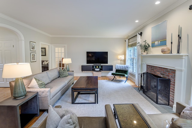 38 Old Trolley Rd, Ridgefield, CT 06877 - living area with ornamental molding, wood finished floors, a brick fireplace, arched walkways, and recessed lighting