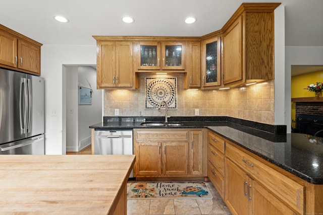 2 Pine Hill Rd, New Fairfield, CT 06812 - kitchen featuring stainless steel appliances, a sink, brown cabinetry, decorative backsplash, and dark stone counters
