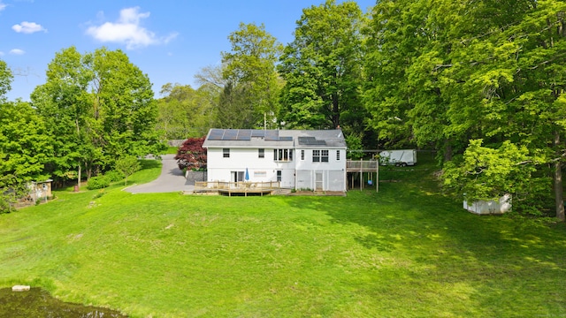 2 Pine Hill Rd, New Fairfield, CT 06812 - rear view of house featuring a deck, a yard, roof mounted solar panels, and a view of trees