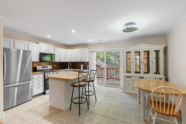 142 Summit St Unit 142, Norwich, CT 06360 - kitchen with appliances with stainless steel finishes, butcher block counters, a breakfast bar area, crown molding, and backsplash