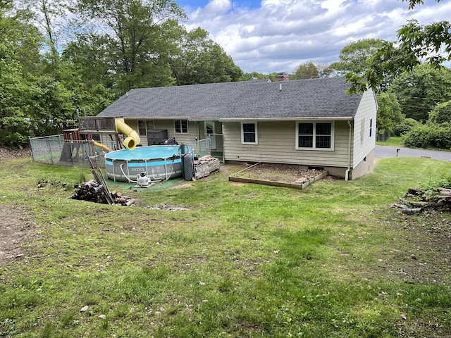 39 Eastwood Rd, Bristol, CT 06010 - back of property with an outdoor pool, a lawn, a chimney, and roof with shingles