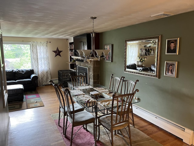 39 Eastwood Rd, Bristol, CT 06010 - dining space featuring baseboard heating, wood finished floors, and a fireplace
