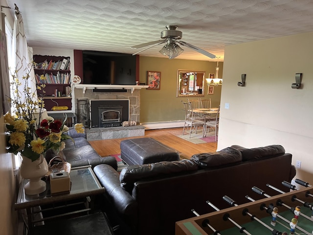 39 Eastwood Rd, Bristol, CT 06010 - living area with a ceiling fan, wood finished floors, a baseboard heating unit, and a stone fireplace