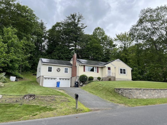 39 Eastwood Rd, Bristol, CT 06010 - view of front of property with an attached garage, driveway, solar panels, and a front yard