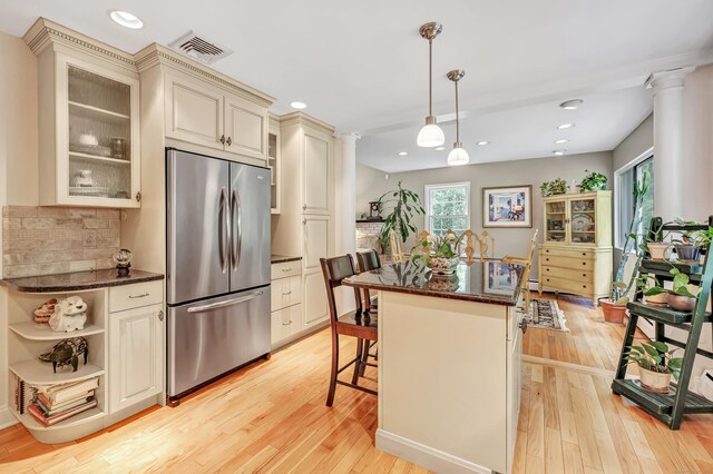6 Rivergate Woods, Wilton, CT 06897 - kitchen with stainless steel refrigerator, cream cabinets, decorative columns, a breakfast bar area, and light wood-style floors