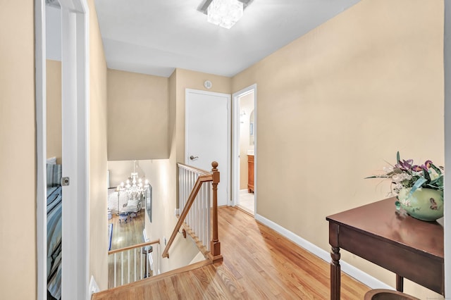 6 Rivergate Woods, Wilton, CT 06897 - corridor featuring an upstairs landing, a chandelier, light wood-style flooring, and baseboards