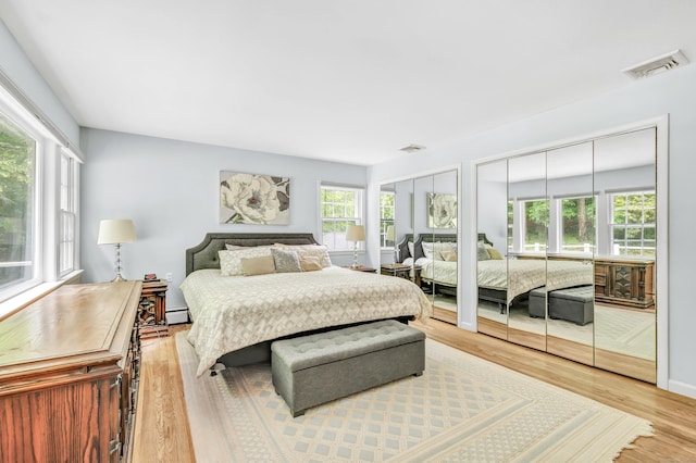 6 Rivergate Woods, Wilton, CT 06897 - bedroom with two closets, multiple windows, wood finished floors, and a baseboard heating unit