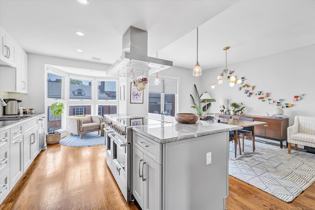 40 Temple Ct Unit 40, New Haven, CT 06511 - kitchen with stainless steel appliances, open floor plan, light wood-style flooring, a kitchen island, and light stone counters