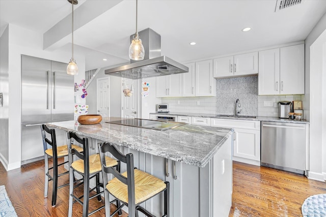 40 Temple Ct Unit 40, New Haven, CT 06511 - kitchen with appliances with stainless steel finishes, extractor fan, wood finished floors, decorative backsplash, and light stone countertops