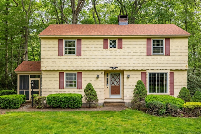 10 Laurel Glen Dr, East Hampton, CT 06424 - colonial home featuring a chimney, a sunroom, a front lawn, roof with shingles, and view of scattered trees