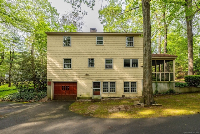 10 Laurel Glen Dr, East Hampton, CT 06424 - back of property with a sunroom, a chimney, driveway, and a garage