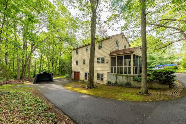 10 Laurel Glen Dr, East Hampton, CT 06424 - view of side of property with a sunroom, asphalt driveway, and a garage