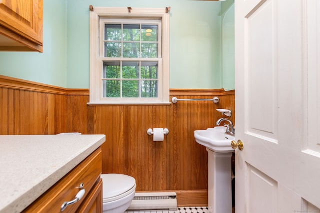 10 Laurel Glen Dr, East Hampton, CT 06424 - half bathroom featuring a baseboard heating unit, wainscoting, toilet, wooden walls, and a sink