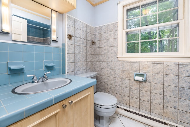 10 Laurel Glen Dr, East Hampton, CT 06424 - bathroom with a baseboard radiator, tile walls, toilet, vanity, and tile patterned floors
