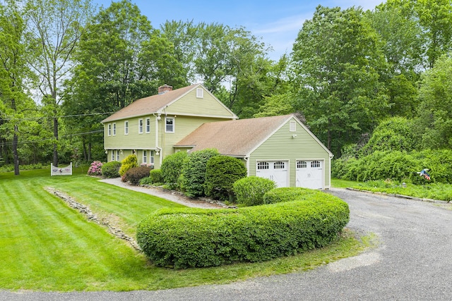 103 Pine St, Columbia, CT 06237 - view of front facade featuring asphalt driveway, a front yard, an attached garage, and a chimney