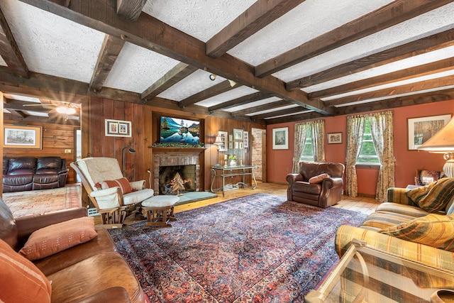 103 Pine St, Columbia, CT 06237 - living area featuring wooden walls, beamed ceiling, a textured ceiling, and a fireplace