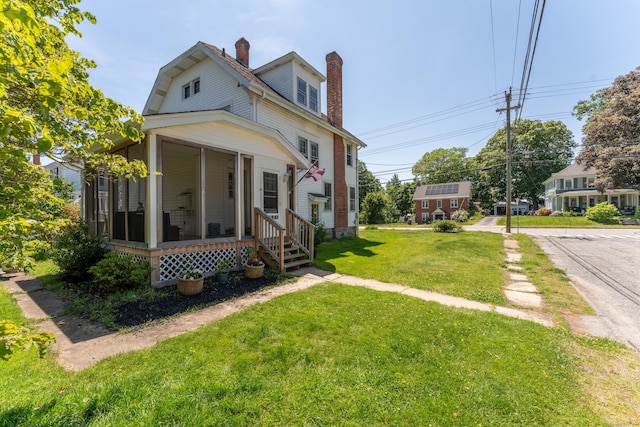 90 Broad St, Killingly, CT 06239 - view of front of house featuring a chimney, a sunroom, and a front yard