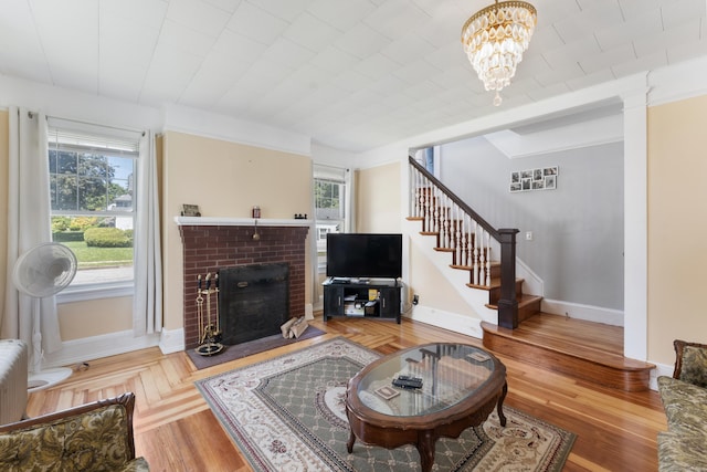 90 Broad St, Killingly, CT 06239 - living area with stairway, plenty of natural light, a brick fireplace, and a chandelier
