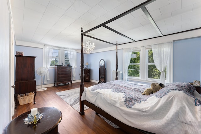 90 Broad St, Killingly, CT 06239 - bedroom featuring radiator heating unit, wood finished floors, and a chandelier