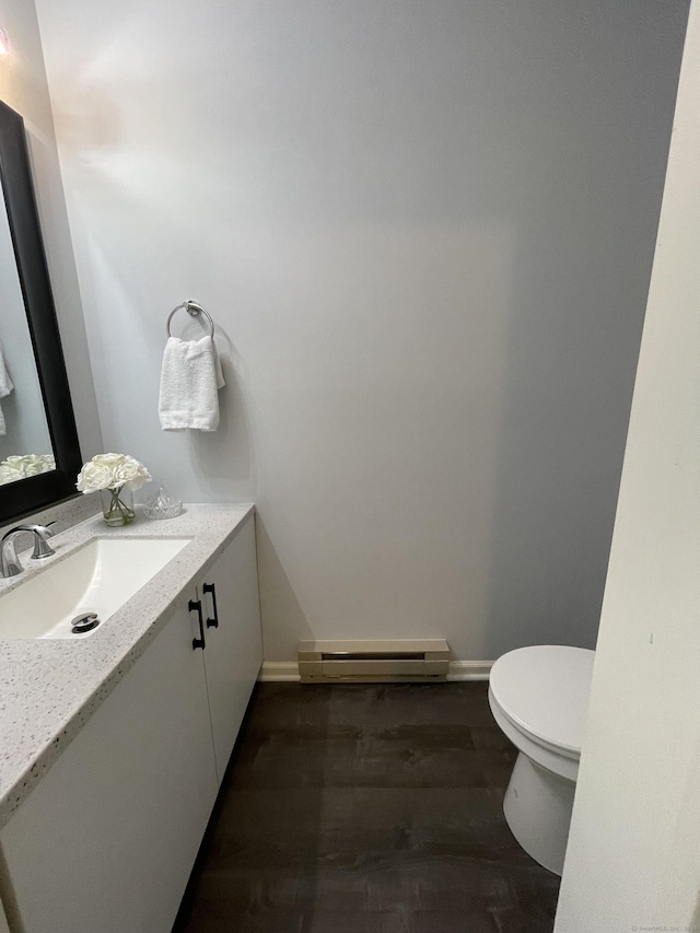 782 Oronoke Rd Apt 33, Waterbury, CT 06708 - bathroom featuring baseboard heating, vanity, toilet, wood finished floors, and baseboards