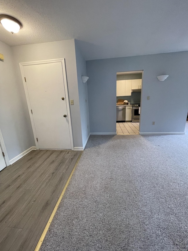 782 Oronoke Rd Apt 33, Waterbury, CT 06708 - unfurnished living room with baseboards, light wood finished floors, and a textured ceiling