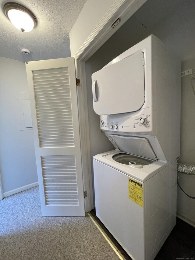 782 Oronoke Rd Apt 33, Waterbury, CT 06708 - laundry room featuring stacked washer and clothes dryer, a textured ceiling, and carpet floors