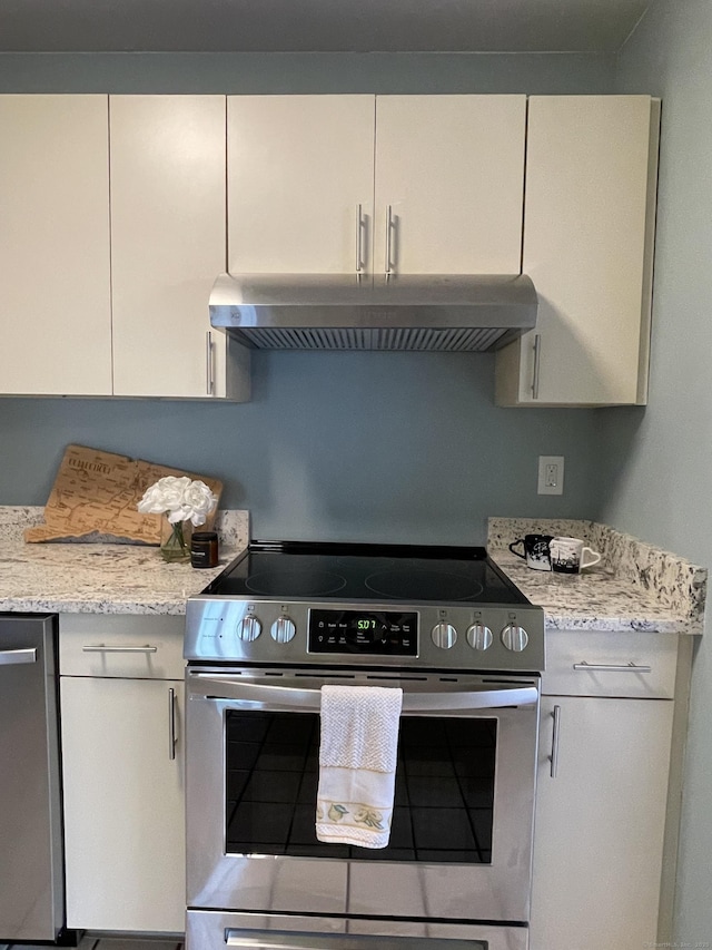 782 Oronoke Rd Apt 33, Waterbury, CT 06708 - kitchen with stainless steel appliances, under cabinet range hood, white cabinetry, and light stone counters