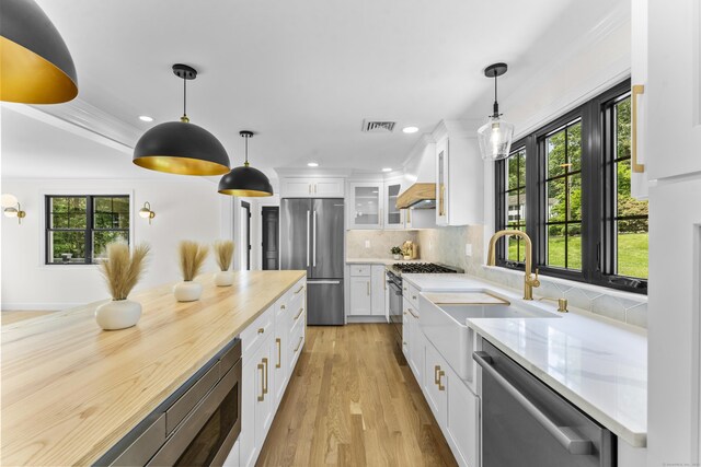 193 Stoner Dr, West Hartford, CT 06107 - kitchen with appliances with stainless steel finishes, white cabinets, glass insert cabinets, tasteful backsplash, and recessed lighting